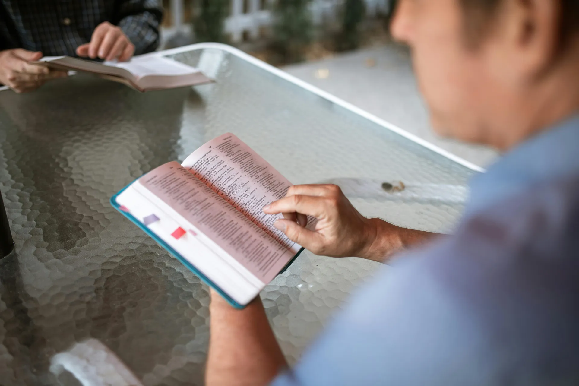People gathered around a table studying open Bibles together